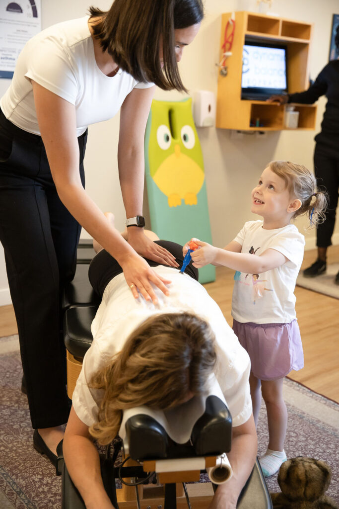 Chiropractor With Child During Session